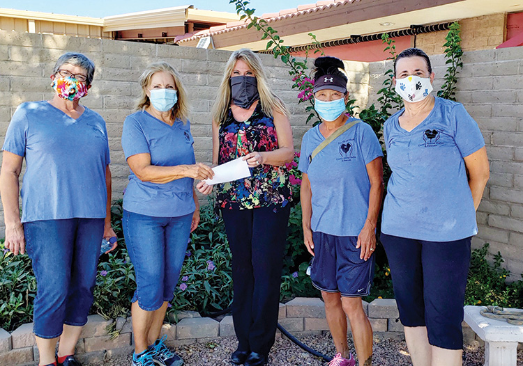 Audra Michael, director of Pinal County Animal Care and Control (center) accepts a check from Mera Laureys as Friends of Pinal County Animal Shelter & Rescues, Inc. volunteers Julie Furgason (far left), Alice Link Lopez, and Kathi Ryzska look on.