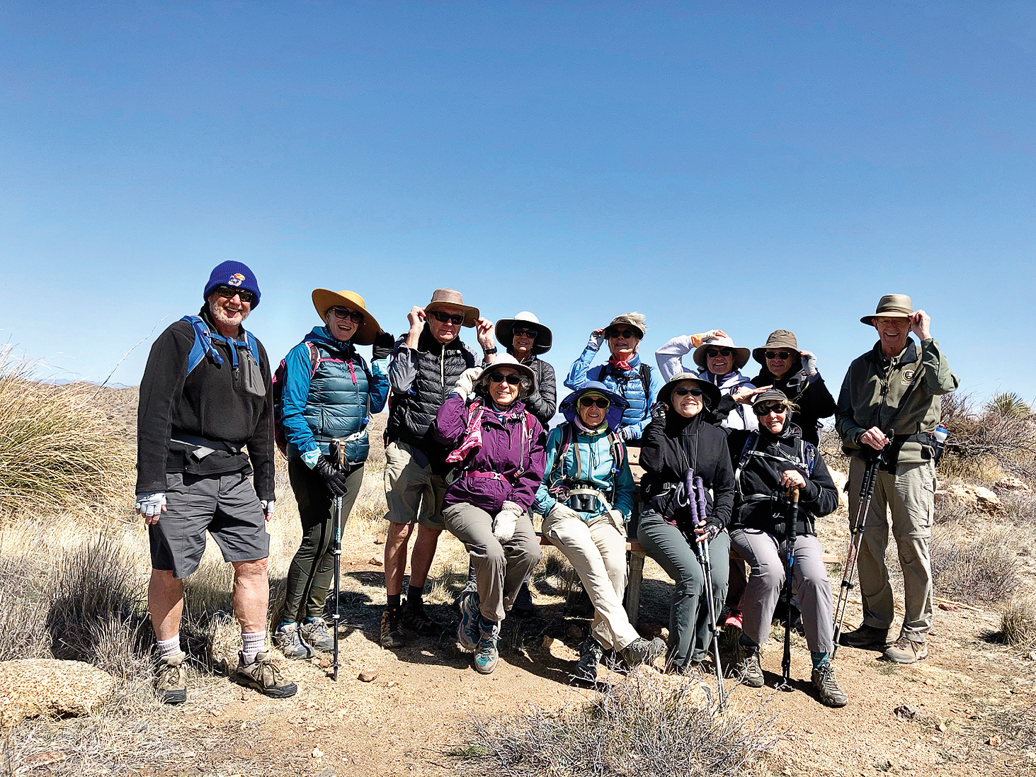 Hikers hold their hats at the Wildlife Corridor Bench (Photo by Lynda Green)