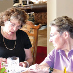 Sigrid Silverman, social chairperson, left, and Gretchen Kolsrud confer on plans for the May picnic at the April luncheon.