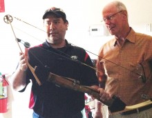 Bobby Vargas from PSE Marketing Department shows Ed Snyder some features of a compound bow.