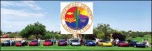 Club members gather at the Vette logo sign.