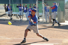 Tom Klein takes a mighty swing while Jim Smith warms up; photo by Ron Finelli.