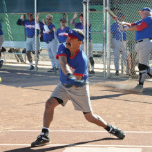 Tom Klein takes a mighty swing while Jim Smith warms up; photo by Ron Finelli.