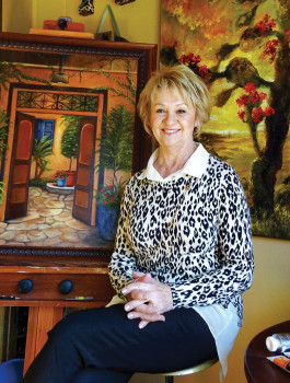 Cheri Allen poses with a “signature” painting.