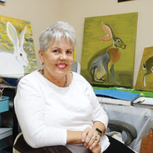 Kathleen Junker pauses in her studio surrounded by several works in progress.
