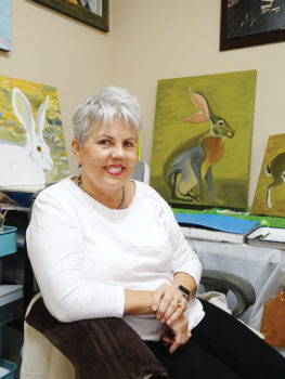 Kathleen Junker pauses in her studio surrounded by several works in progress.