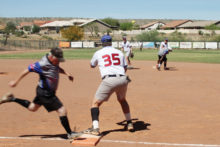 This Apache Junction runner is safe as the throw from second baseman Steve Garceau to first baseman Bob Chiarello doesn’t make it in time; photo by Jim Smith.