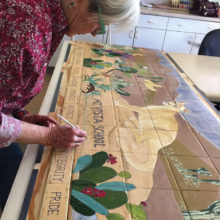 SaddleBrooke Pottery Club member Harriet Hason puts the finishing details on a desert scene mural prior to kiln firing the ceramic tiles. The mural is the club’s community service project for Mountain Vista School in Oracle.
