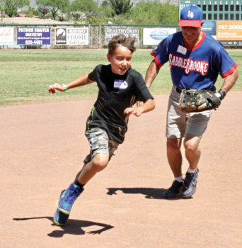 Coach Q tries to put the tag on Ethan as he rounds the bases; photo by Jim Smith.