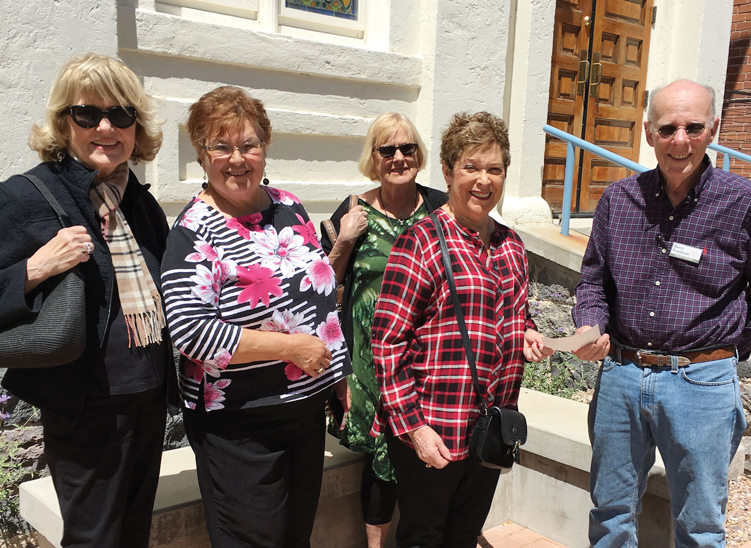 In front of the 1910 synagogue are Quester members Marilyn Bertke, Rose Meyer, Linda Holt and Libby Cohen presenting the check to JHM Board President Barry Friedman.
