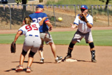 Janice Mihora flips the ball to Greg Morgan but it looks like runner Dale Norgard is safe.