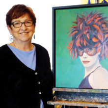 Sandy Merritt poses in her studio with Boa Head, one of her favorite portraits.