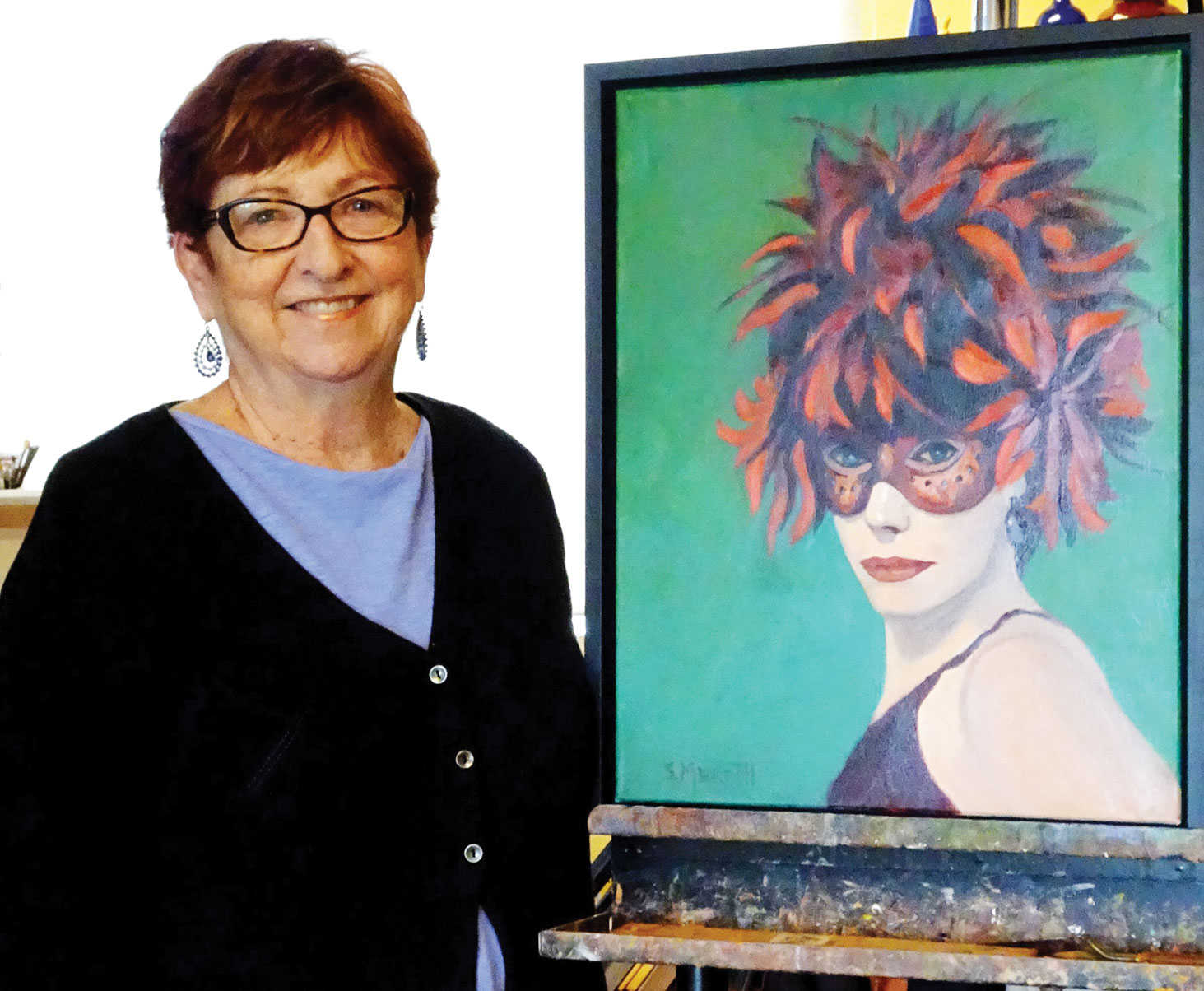 Sandy Merritt poses in her studio with Boa Head, one of her favorite portraits.