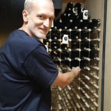 Dave in front of wine cooler which holds 440 bottles