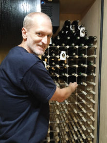 Dave in front of wine cooler which holds 440 bottles