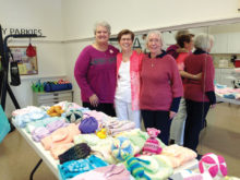 Beth Bradford, Georgiann Schwetz and Dianne Resseguie admire one table of baby donations.