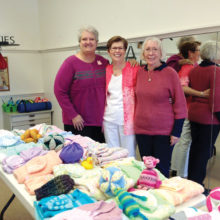 Beth Bradford, Georgiann Schwetz and Dianne Resseguie admire one table of baby donations.