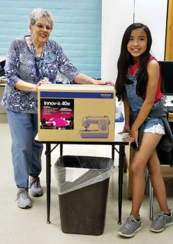 Student Tianni Whitman with TSC mentor Judy Hans presenting the new sewing machine.