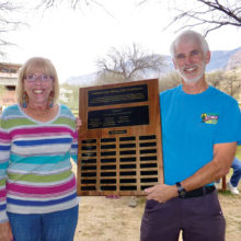 Randy Park honors volunteer Carole Rossof; her name is now engraved on the honor roll plaque outside the HOA 1 Golf Pro Shop; photo by Elisabeth Wheeler.