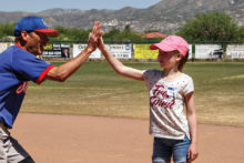 Cora gets a high five from Coach Jeff Stolze; photo by Jim Smith.