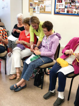 Pat Lenz offers assistance to her students in the Portuguese knitting class; photo by Georgiann Schwetz.