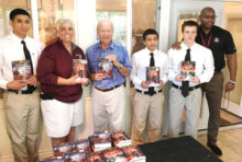 SaddleBrooke Rotarian George Corrigan (center) distributing books to students and staff at Sycamore Canyon Academy