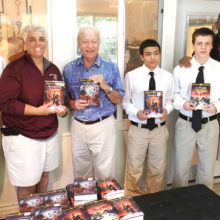 SaddleBrooke Rotarian George Corrigan (center) distributing books to students and staff at Sycamore Canyon Academy