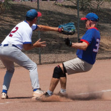 Competitive: Harold Weinenger reaches to tag runner Don Jones as he stirs up the dust at third base; photo by Dennis Purcell