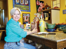 Harriet Hason shows a trio of her clay figures at the work table in her home studio.