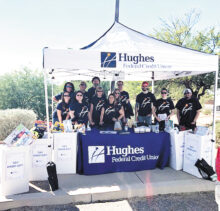 Hughes employees and volunteers pose with five bins of toys collected for Banner Children’s at Holiday Toy Drive kick-off event.