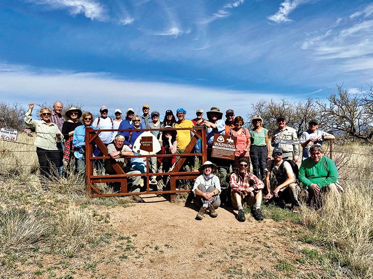 Trail workers pose before a trail gate. Photo by Zach MacDonald.