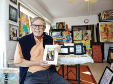 Paul Kopp displays a miniature photograph from one of his original pieces in his painting-filled studio. (Photo by LaVerne Kyriss)