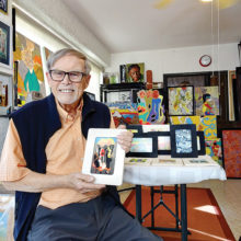 Paul Kopp displays a miniature photograph from one of his original pieces in his painting-filled studio. (Photo by LaVerne Kyriss)