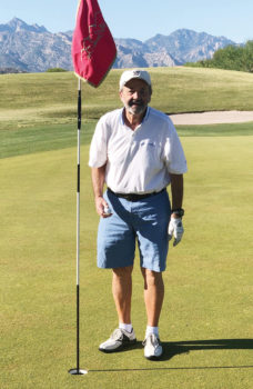 Rich Wilson standing by the third hole flag on the Catalina course at SaddleBrooke (Photo by Bob Eder)