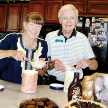 Arlene DesJardins and David Dodd serving up dishes of ice cream