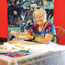 Greta von Wrangel carefully applies wax in a detailed pattern as she creates a batik design. (Photo by LaVerne Kyriss)
