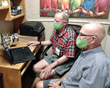 Volunteer Bill Lunquist helping Village member Bill Smith install a new computer and printer