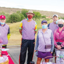 Larry McNamee, admiring the check-in table and gift bags prepared by wife, Loralee; Dan Nordhill; Event Chair, Loralee Horwedel; Matt Kambic; and Barbara Bloch, dressed in plum to honor cancer caregivers. (Photo by Bill George)