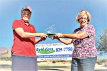 Donna Watson (left) with a big splash of sparkle in her smile, prize hat, and trophy after the winner’s presentation by Mary Kay Nordhill. (Photo by Anne Cole)